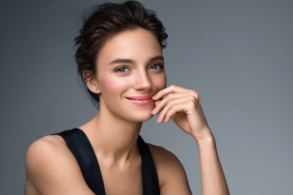 a woman smiling with her hand on her chin