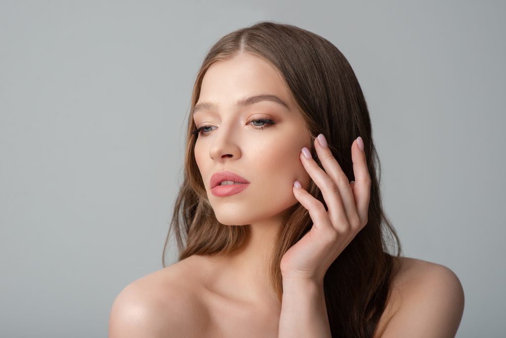 a woman with long hair touching her face